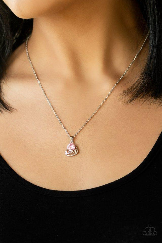 Turn On The Charm Pink Cubic Zirconia Necklace features a shimmery silver heart with word "love".